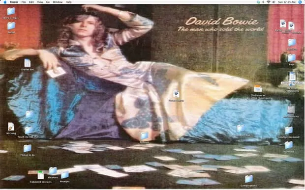 a screenshot of a messy old mac desktop with david bowie&#x27;s album cover for the man who sold the world as a wallpaper